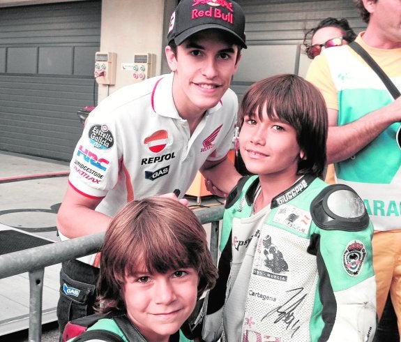 Álvaro Carpe, en primer término, junto a su hermano Antonio y Marc Márquez, campeón del mundo de MotoGP, en Cheste. 