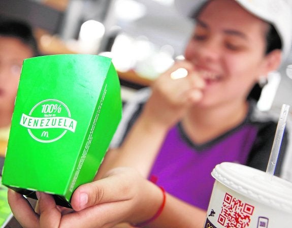 Una mujer come yucas fritas en un McDonald's de Caracas. 