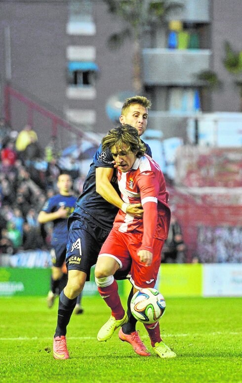 Prosi es agarrado por un rival, en el partido de ayer. 