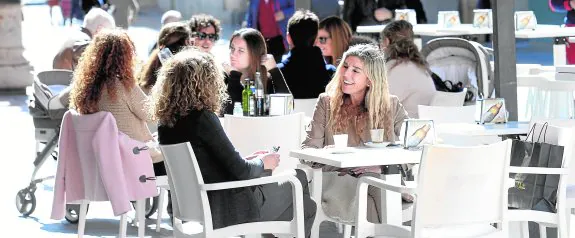 Clientes disfrutan de una terraza en la calle Puertas de Murcia. 