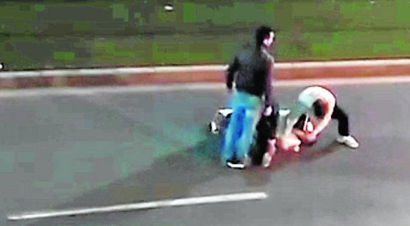 Los jóvenes, reteniendo al agresor de su pareja. 