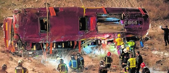 Imagen del autobús volcado, en la que se aprecia que los mayores daños están en el lado derecho (inferior de la fotografia). 