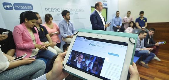 El candidato del PP a la Asamblea Regional, Pedro Antonio Sánchez, presentando su web de campaña junto a jóvenes militantes. 