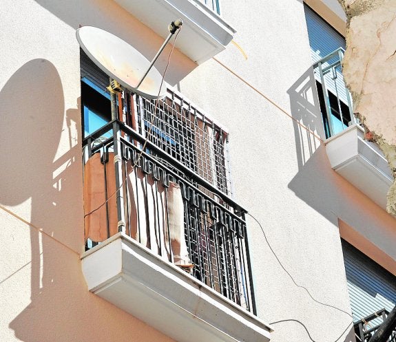 Dos somieres, una antena parabólica y cartones se agolpan en este balcón de la calle Echegaray en pleno centro.
