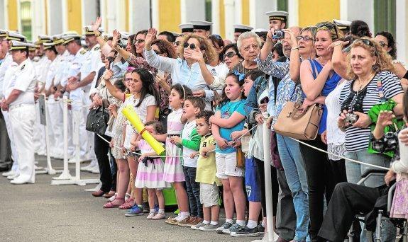 Familiares de tripulantes saludan desde el muelle mientras el 'Hespérides' maniobra en la dársena militar. 