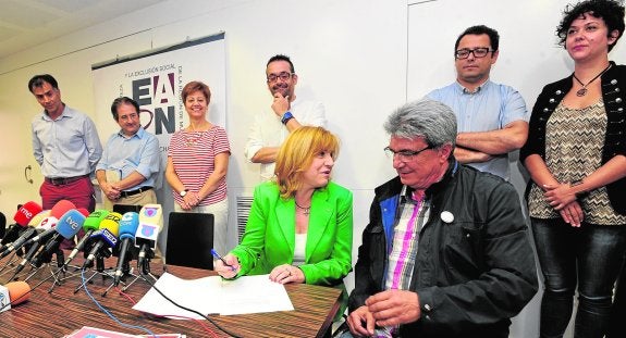 El presidente de la Red de Lucha contra la Pobreza, Diego Cruzado, observa a Violante Tomás (PP) en la firma del pacto. 