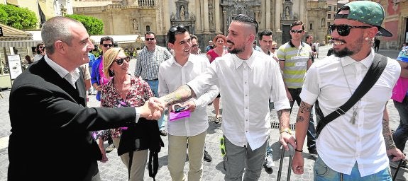 César Nebot saluda a dos turistas en presencia de Rosa Díez y Rubén Serna, ayer, en la plaza Belluga. 