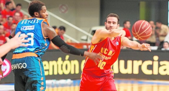 Carlos Cabezas da un pase a un compañero en el UCAM-Valencia Basket de esta temporada. 