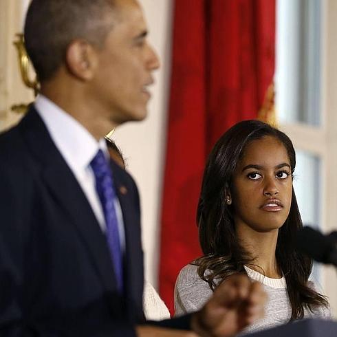 Malia Obama escuchando a su padre durante el día de Acción de Gracias en La Casa Blanca, Washington. 