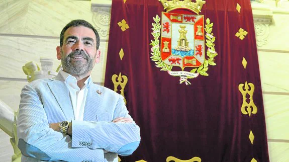 José López, junto a la bandera con el escudo de Cartagena que adorna la escalinata del Palacio Consistorial. 