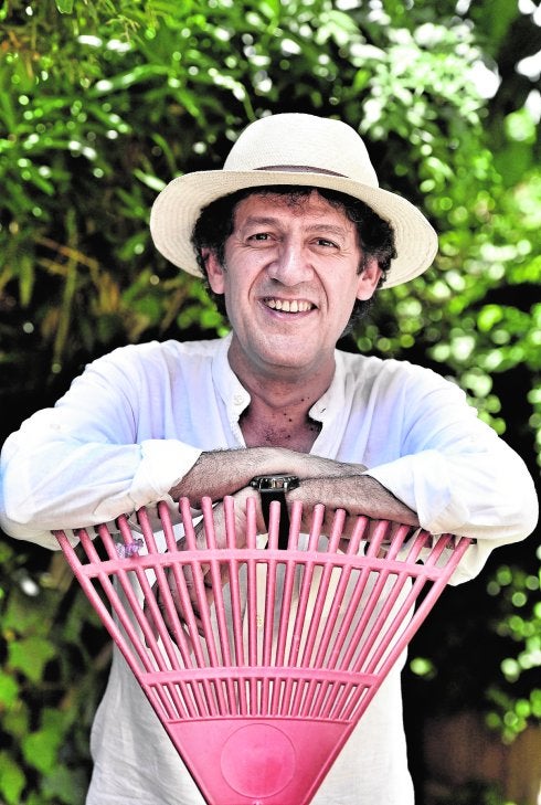 Paco López Mengual, en el jardín de su casa, con un rastrillo. 