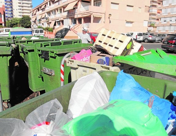 Un vecino tira la basura a media tarde de ayer en los contenedores de Puerto Bello.