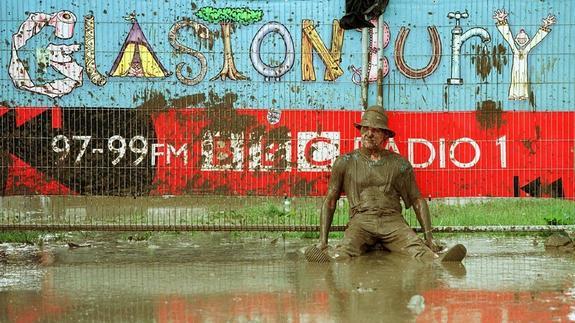 Un asistente del festivas inglés de Glastonbury rebozado en barro en 1998. 