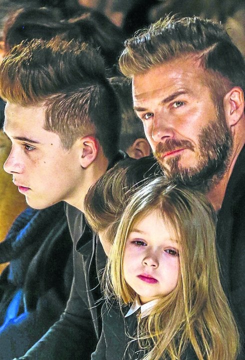 El exfutbolista junto a sus hijos Brooklyn y la pequeña Harper durante un desfile de Victoria Beckham. ::