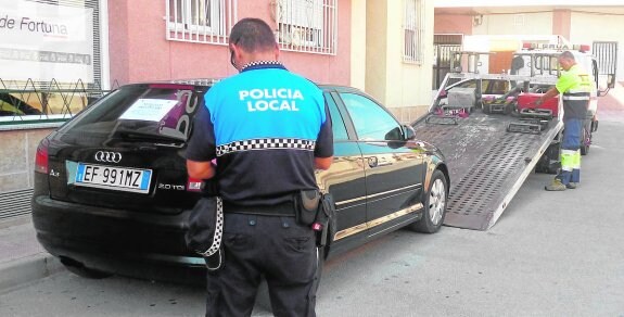 Un agente de la Policía Local de Fortuna supervisa la retirada de uno de los vehículos sin seguro.