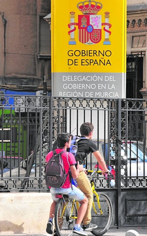 Dos jóvenes ante el edificio de la Delegación del Gobierno.