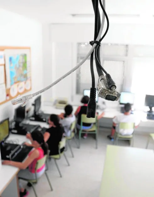 El aula de Informática del colegio Nuestra Señora de Los Ángeles, de la pedanía murciana de El Esparragal, con los cables del proyector, averiado desde el curso pasado, que cuelgan del techo. 