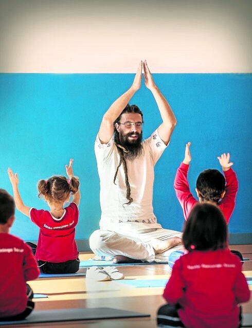 Los niños del colegio Santo Domingo Savio adoptan la 'asana' de la montaña, instruidos por Moncho, el profesor de yoga.
