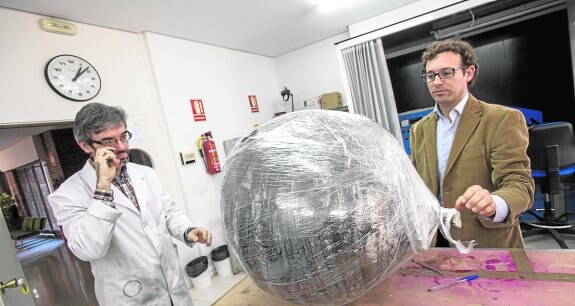 Personal del centro, ayer, envolviendo con plástico la esfera espacial para protegerla.