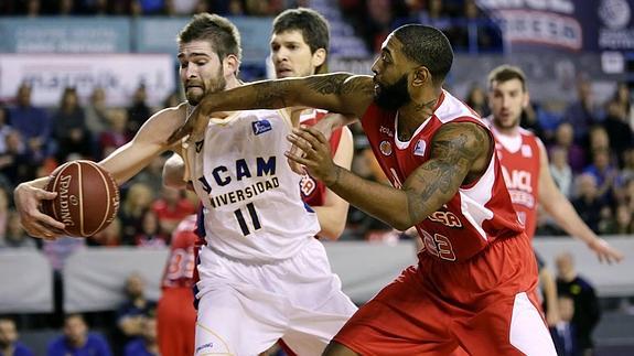 Un jugador del UCAM lucha el balón con uno del Manresa. 