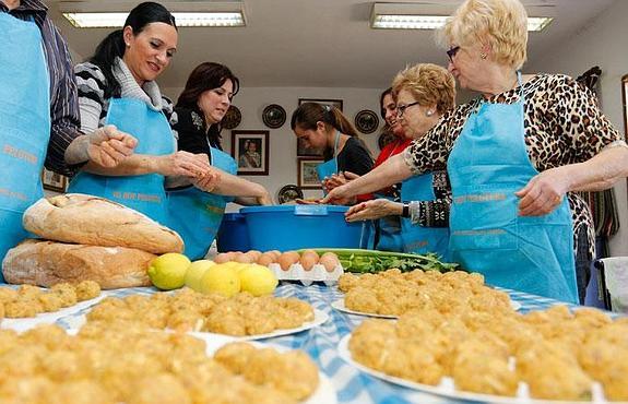 Componentes de la peña La Hijuela, este sábado, preparando las tradicionales pelotas que se degustarán este domingo en Patiño.