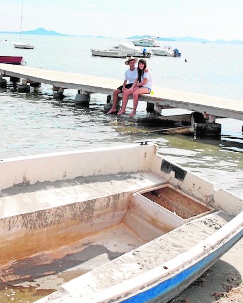 Una pareja, en verano, en el muelle de las obras adjudicadas. :: A. S.
