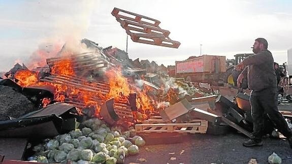 Productores franceses, incendiando el martes la carga de un camión de la Región asaltado en Arlés.