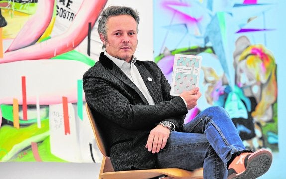 Nacho Ruiz, con su libro, en la galería T20 de Murcia, de la que es codirector.