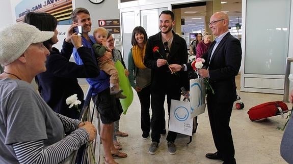 El consejero Hernández entre un clavel a uno de los pasajeros del vuelo tras desembarcar.