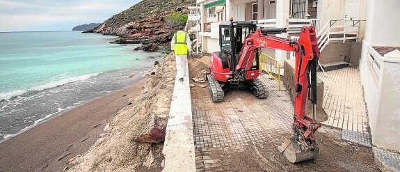 Obreros trabajando con una excavadora pequeña en el arreglo de la parte del paseo marítimo de El Portús que se hundió en la madrugada del martes. 