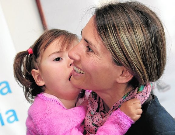 Inmaculada sonríe mientras coge, ayer, en brazos a su hija, Martina. 