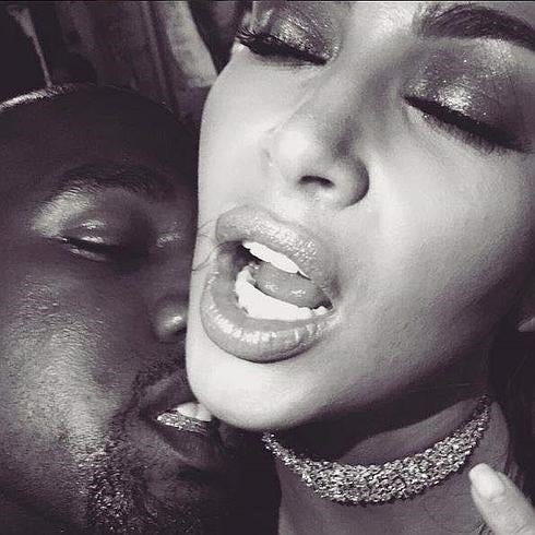 Kanye West trata de morder el cuello de Kim Kardashian.