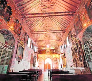 Este barco  suspendido del artesonado es un ex-voto, un tributo a La Santa por su intercesión bien en un hecho milagroso naval, bien por el agradecimiento de un indiano por su prosperidad. Es una pieza verdaderamente excepcional. Está ejecutado con una técnica poco común en la Región y con materiales entretejidos que aligeran su peso, en vez de en madera, lo más habitual. Es una carraca o un galeón muy simplificado que, sin embargo, tiene tres palos, lo que hace pensar en una nave del siglo XVIII, así como el número de velas, si bien la intención no es totalmente realista. Hace siglos fue frecuente colgar objetos especialemente raros o simbólicos en los techos y paredes de iglesias, que se fueron retirando con el tiempo. Hoy quedan pocos, como el cocodrilo disecado de la Iglesia del Patriarca en Valencia o el de la Catedral de Sevilla. Su permanencia evidencia el alto valor que siempre se le concedió.