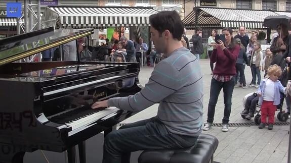 Uno de los participantes toca el piano en una plaza de Murcia.