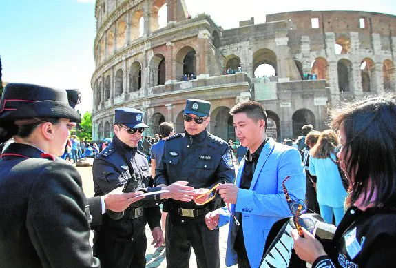 Dos agentes de policía chinos atienden a un compatriota ante el Coliseo romano. :: r. c.