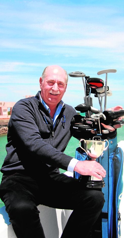 Pedro Díaz posa con su copa más preciada y varios de los 'putters' que guarda en su casa. 