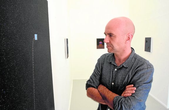 El artista Aitor Lajarín, junto a una de sus obras, en Art Nueve. 