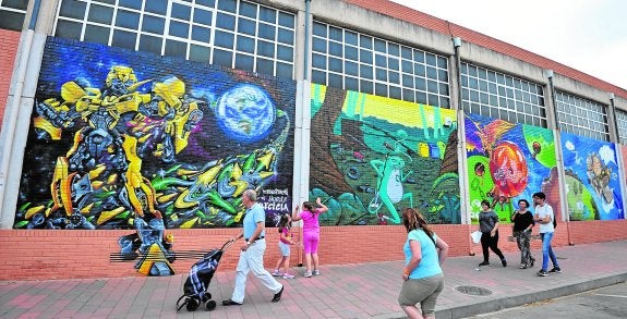 El enorme mural dedicado al reciclaje en una de las fachadas de la piscina del Infante. 