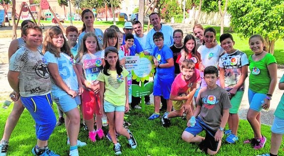 El edil José Guillén con los alumnos en la plantación de flores. 