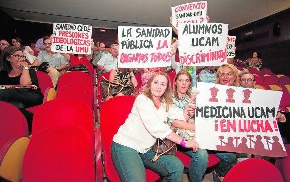 Alumnos y profesores de la UCAM, con pancartas reivindicativas, ayer en el Moneo. 