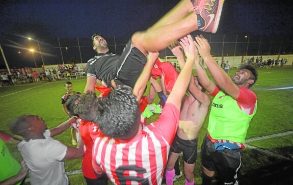 Los jugadores del CD Algar mantean a Popi, su entrenador, tras lograr el ascenso a Tercera, el pasado miércoles.