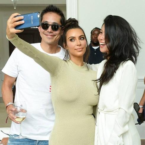 Kim Kardashian posando con unos fans en los Hamptons. 