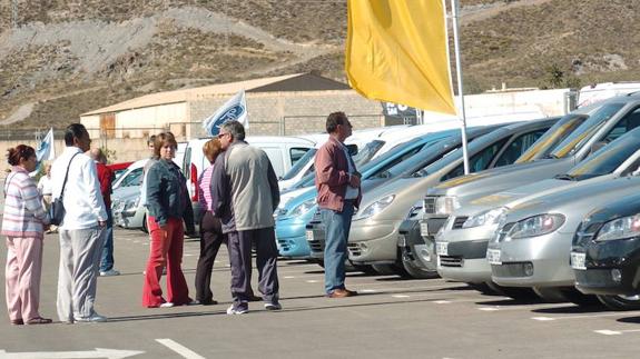 Varios clientes miran coches de segunda mano en Lorca. 