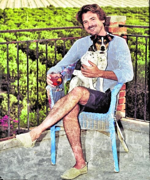 Rafael Fuster, con su perra 'Luna' y un Aperol Spritz en la mano, en la terraza de su casa. 