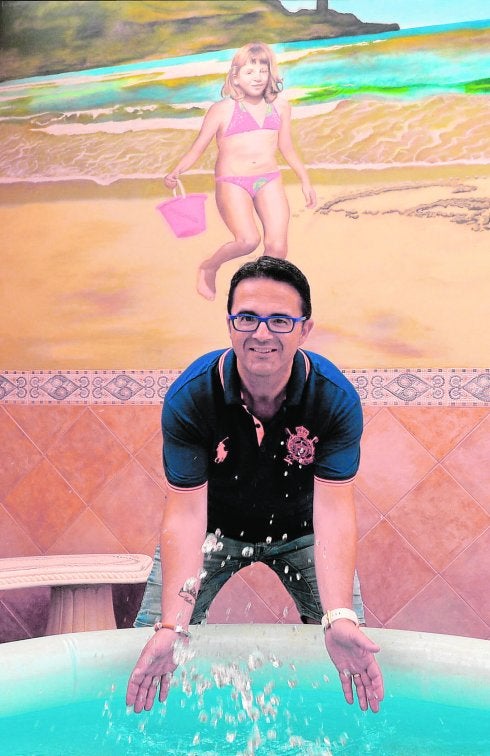 Juan Carrión, en el patio de su casa de Totana, frente al mural dedicado a su hija, fallecida en 2012. 