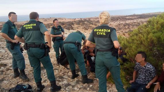 Agentes de la Guardia Civil atienden a los inmigrantes llegados en patera. 