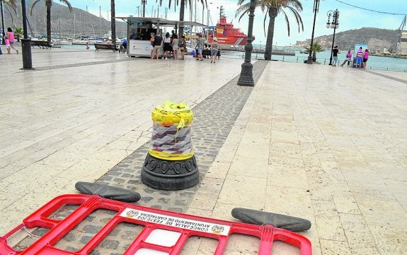 La base de la farola y una valla municipal, en el muelle. agm