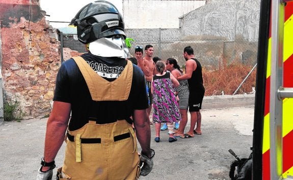 Un bombero junto a la vivienda calcinada. 
