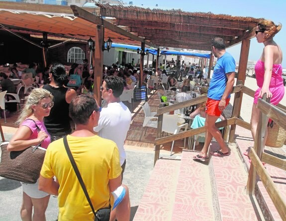 Un grupo de turistas espera junto a la terraza de un restaurante de La Manga una mesa, en una foto de este verano.