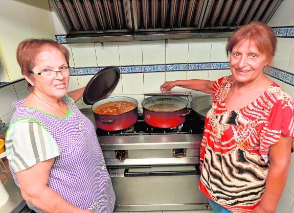 Las cocineras del bar Guardamar, Teresa González y Pascuala Reverte, muestran el guiso de albóndigas.